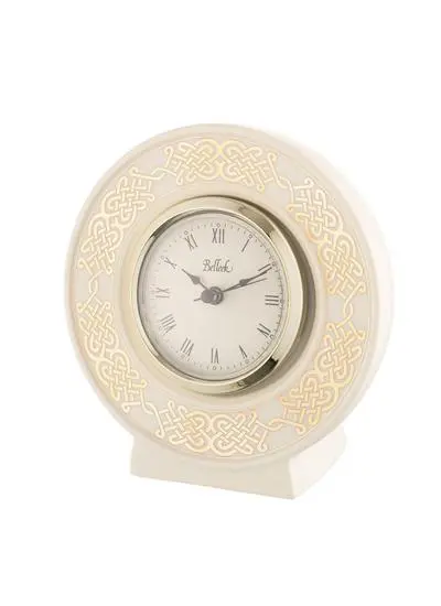 A beige, vintage-style desk clock with ornate golden patterns around the circular face, set in a sleek, supportive stand, isolated on a white background.